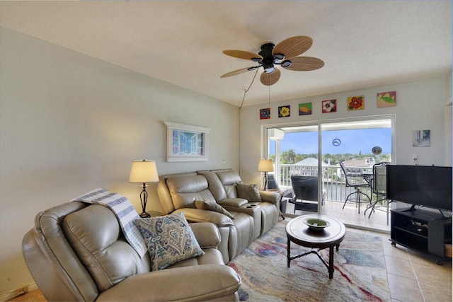 living room featuring ceiling fan, light tile patterned floors, and vaulted ceiling