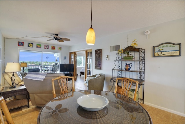 dining space featuring ceiling fan and light tile patterned flooring