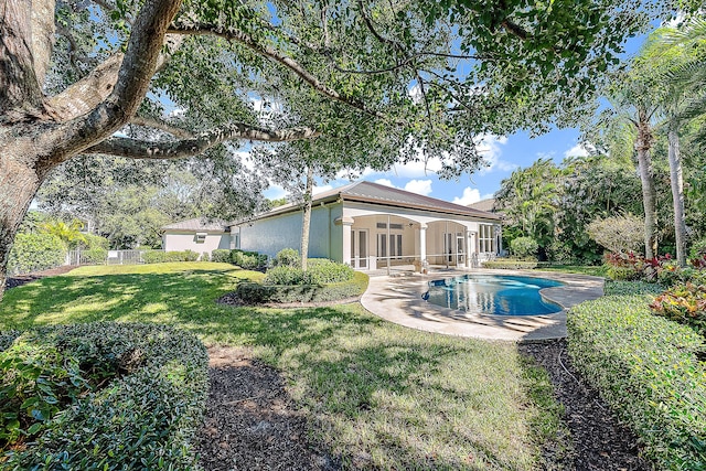 rear view of property featuring a yard, a patio, and ceiling fan