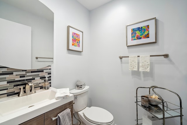 bathroom with vanity, backsplash, and toilet