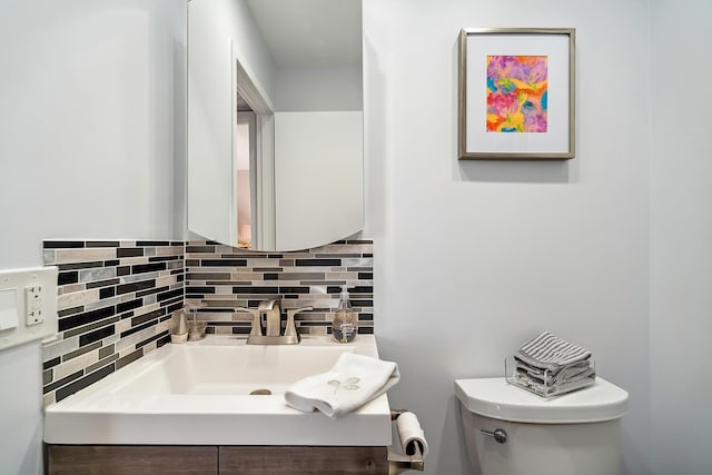 bathroom with vanity, tasteful backsplash, and toilet