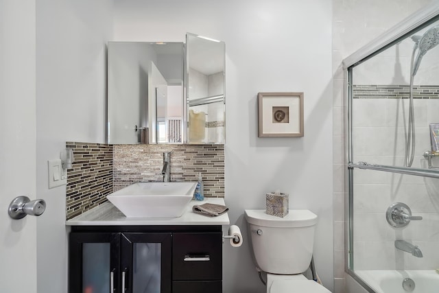 full bathroom with vanity, toilet, shower / bath combination with glass door, and tasteful backsplash