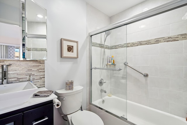 full bathroom with toilet, combined bath / shower with glass door, decorative backsplash, and vanity