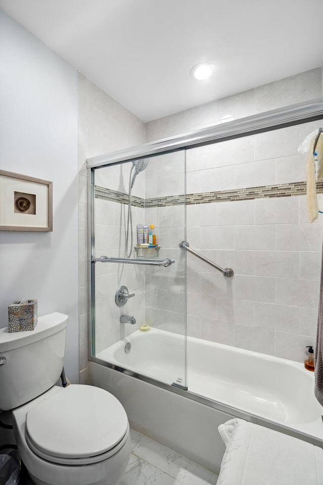 bathroom featuring bath / shower combo with glass door and toilet