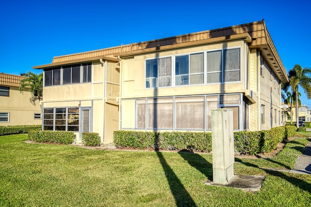 rear view of house featuring a lawn