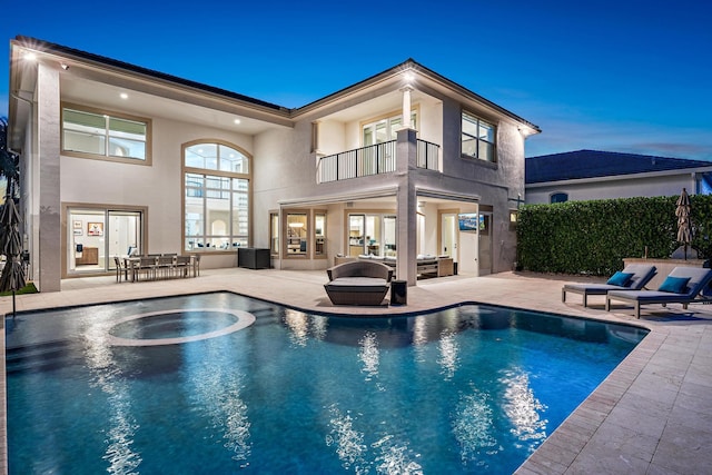 pool at dusk with a patio area, fence, and a fenced in pool