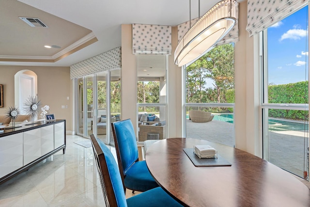 dining space featuring a raised ceiling, visible vents, and crown molding