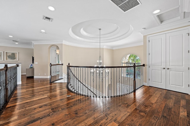 hall featuring dark wood-style floors, visible vents, a notable chandelier, and an upstairs landing