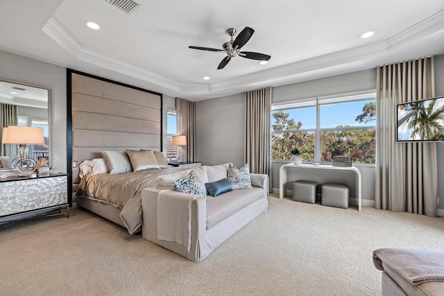 bedroom with carpet floors, a tray ceiling, visible vents, and ornamental molding