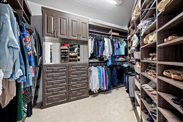 walk in closet featuring light colored carpet