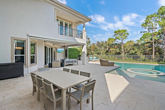 view of pool featuring outdoor lounge area, a patio area, ceiling fan, fence, and an in ground hot tub