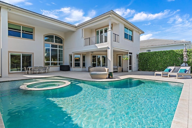 outdoor pool with a patio area and an in ground hot tub