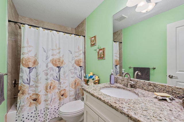 bathroom with vanity, toilet, and a textured ceiling