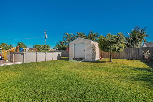 view of yard featuring a fenced in pool and a storage unit