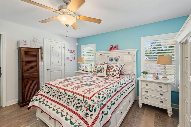 bedroom featuring multiple windows, ceiling fan, and dark hardwood / wood-style flooring