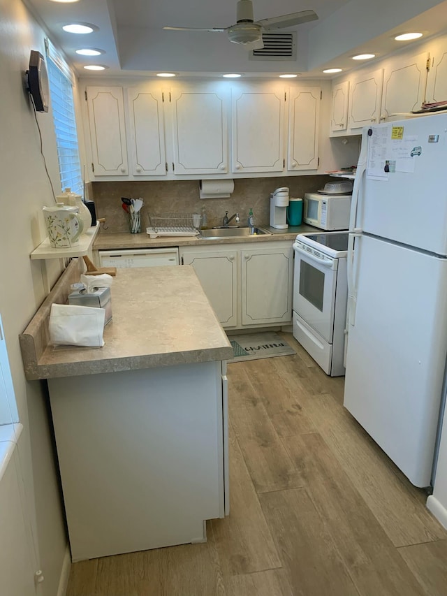 kitchen with light hardwood / wood-style flooring, white cabinets, and white appliances