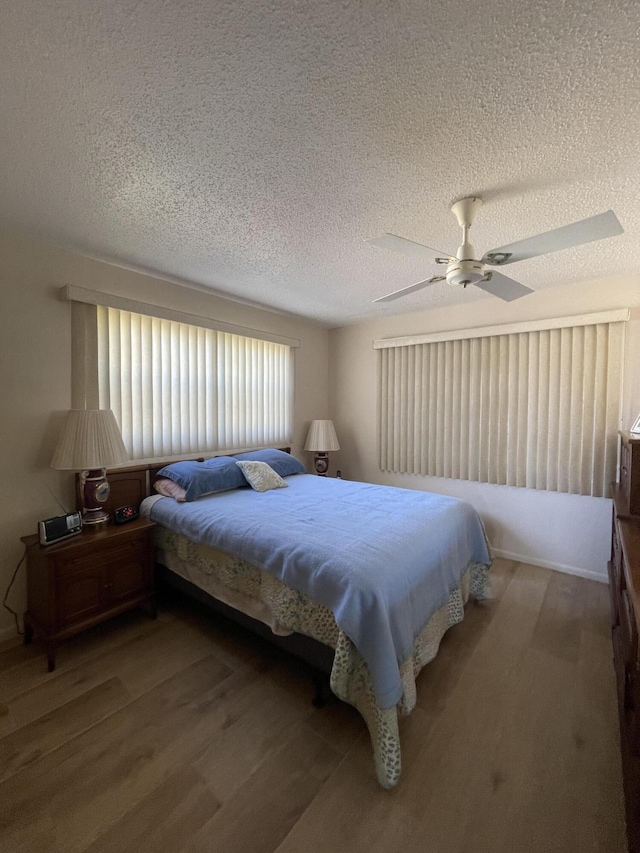 bedroom featuring hardwood / wood-style floors, ceiling fan, and a textured ceiling