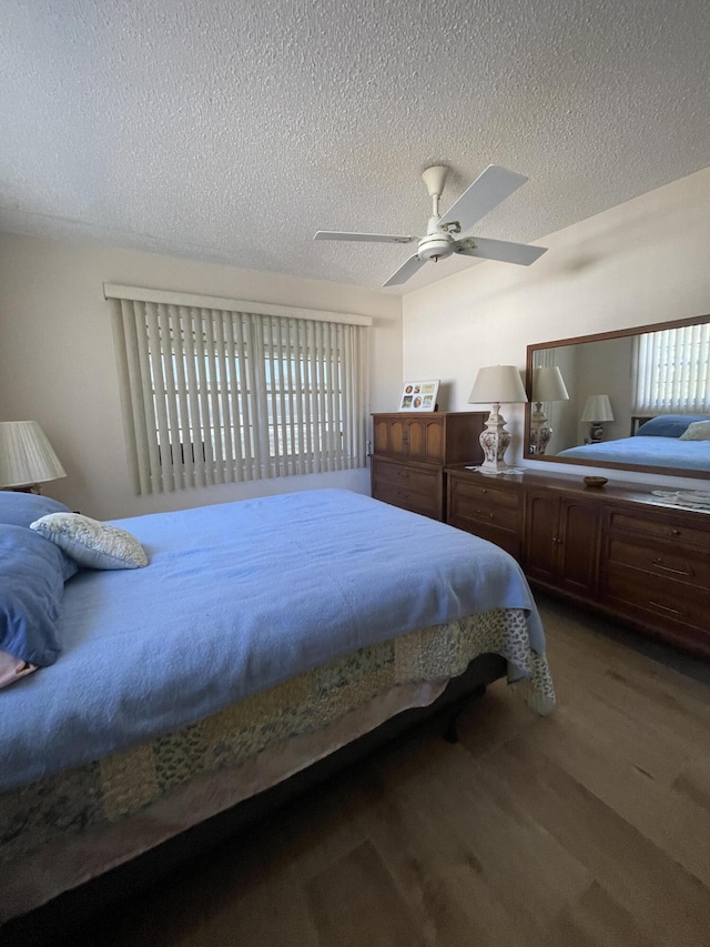 bedroom with ceiling fan, wood-type flooring, and a textured ceiling