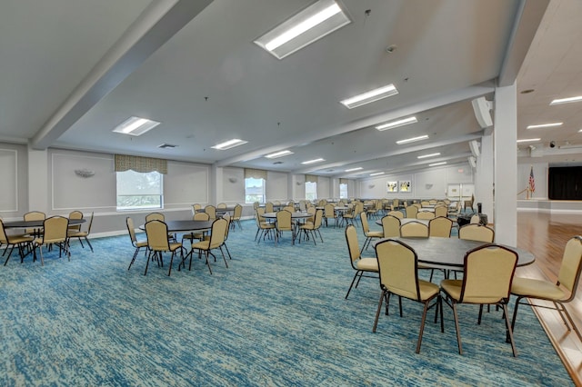 carpeted dining area with lofted ceiling