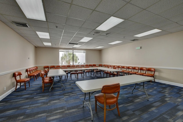 recreation room with a paneled ceiling and dark carpet