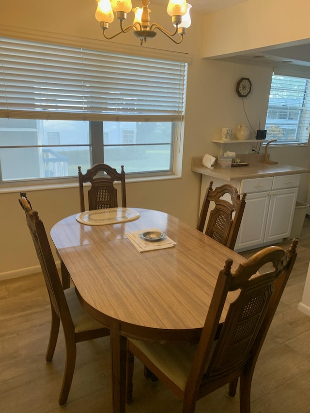 dining room with a healthy amount of sunlight, light hardwood / wood-style flooring, and a chandelier