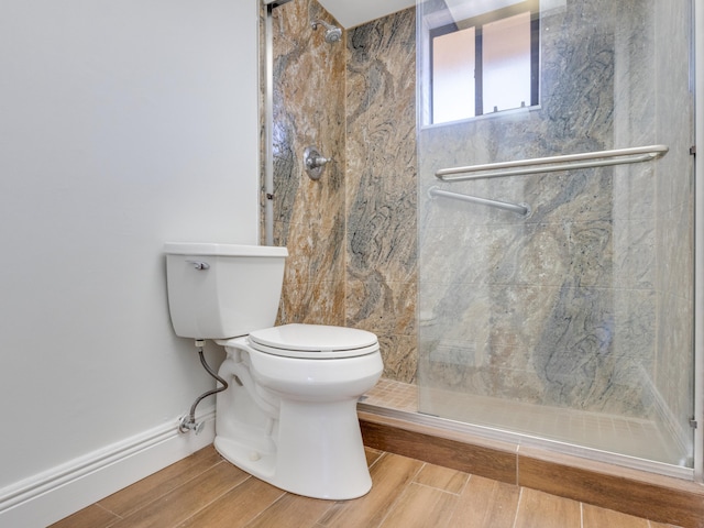 bathroom featuring tiled shower and toilet