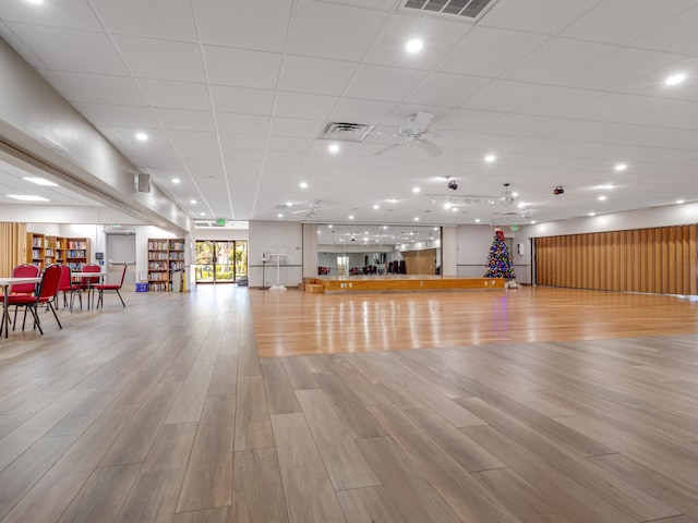 exercise area featuring a paneled ceiling, light hardwood / wood-style floors, and ceiling fan