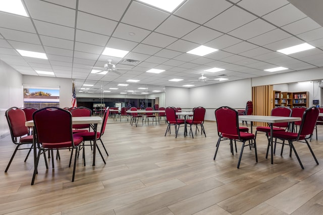 dining area featuring a drop ceiling, light hardwood / wood-style floors, and ceiling fan