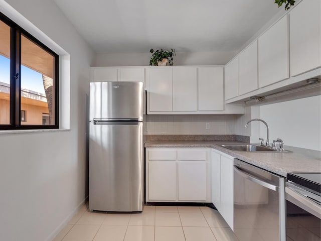 kitchen with white cabinets, light tile patterned flooring, sink, and stainless steel appliances