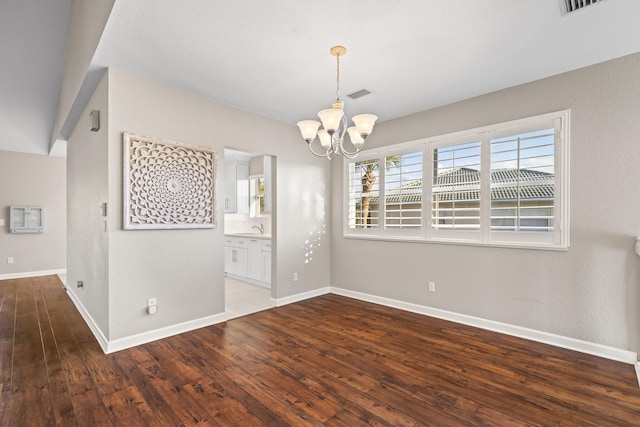 spare room with dark hardwood / wood-style flooring, sink, and an inviting chandelier