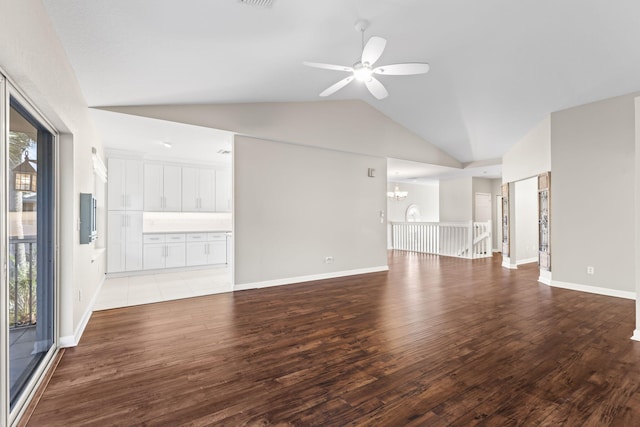 unfurnished living room featuring ceiling fan with notable chandelier, light wood-type flooring, and vaulted ceiling