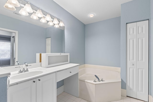 bathroom with tile patterned floors, a tub to relax in, and vanity