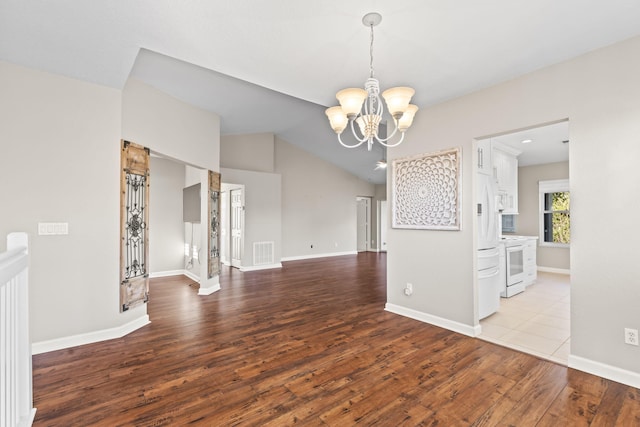 unfurnished dining area featuring vaulted ceiling, a notable chandelier, and light wood-type flooring