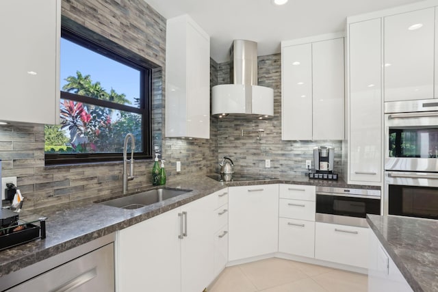 kitchen featuring sink, wall chimney exhaust hood, stainless steel double oven, backsplash, and white cabinets