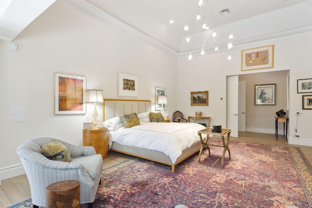 bedroom with hardwood / wood-style flooring and high vaulted ceiling