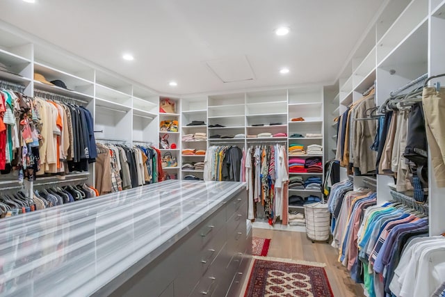 walk in closet with light hardwood / wood-style flooring