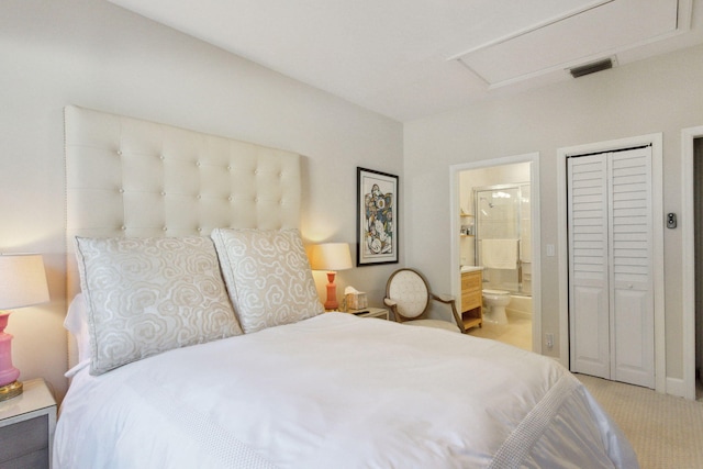 bedroom featuring a closet, light carpet, and ensuite bath