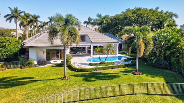 exterior space with a fenced in pool, a patio area, and a yard