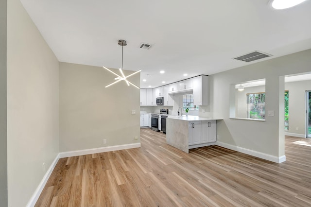 kitchen featuring stainless steel appliances, kitchen peninsula, light wood-type flooring, and white cabinets