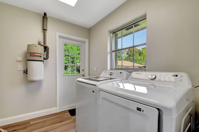 clothes washing area with washer and dryer and light hardwood / wood-style floors