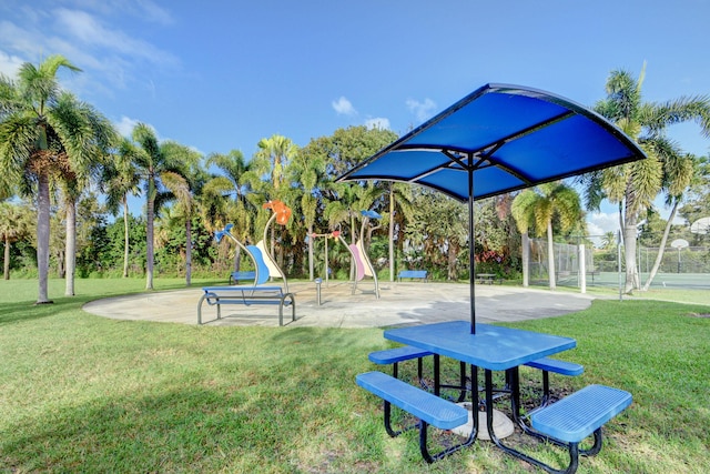 view of home's community featuring tennis court and a lawn