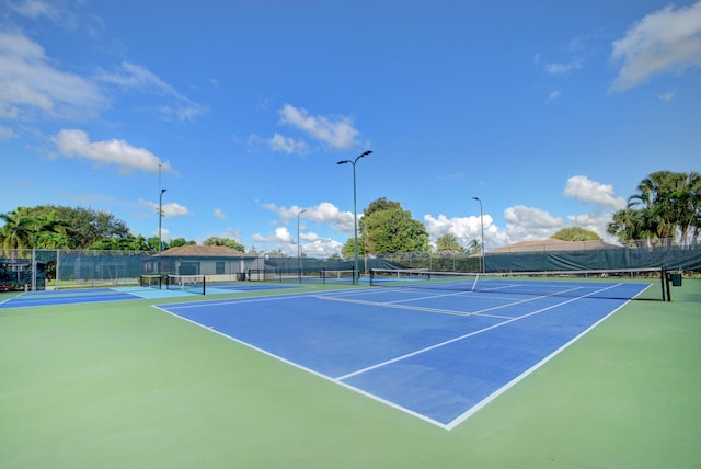 view of tennis court with basketball hoop