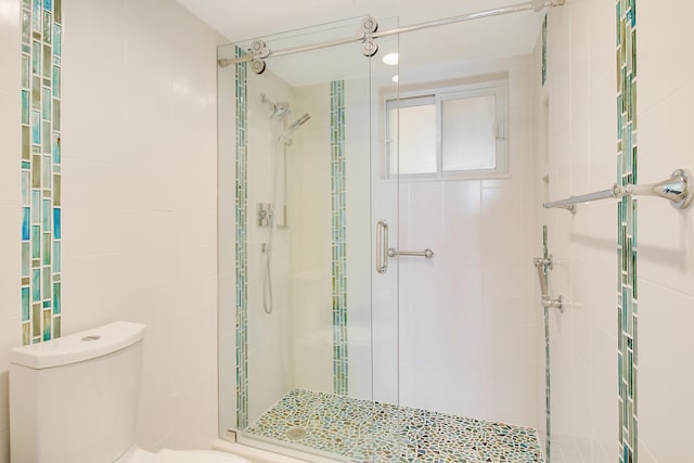 bathroom featuring an enclosed shower and toilet