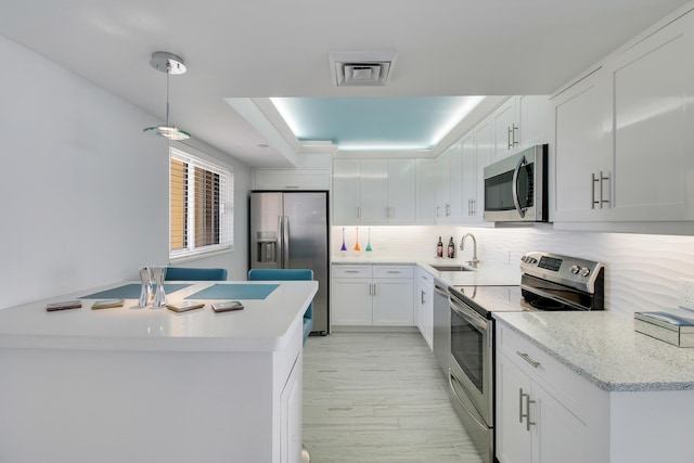 kitchen with white cabinetry, sink, tasteful backsplash, light stone counters, and appliances with stainless steel finishes