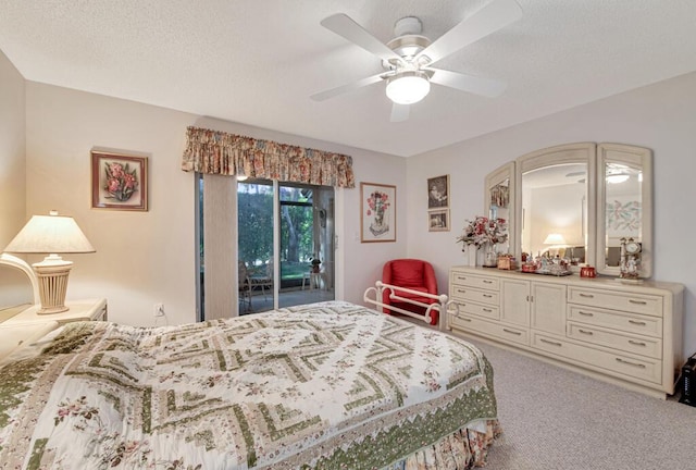 carpeted bedroom with access to exterior, a textured ceiling, and ceiling fan