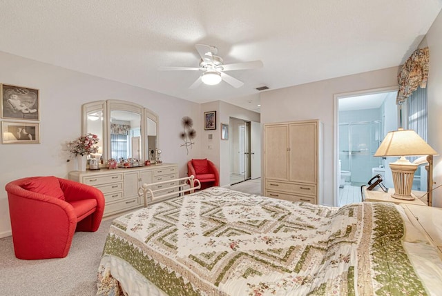 bedroom with ceiling fan, light carpet, and ensuite bath