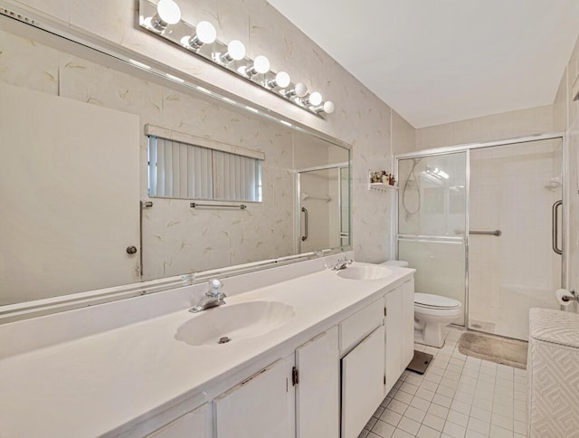 bathroom featuring tile patterned flooring, vanity, toilet, and a shower with door