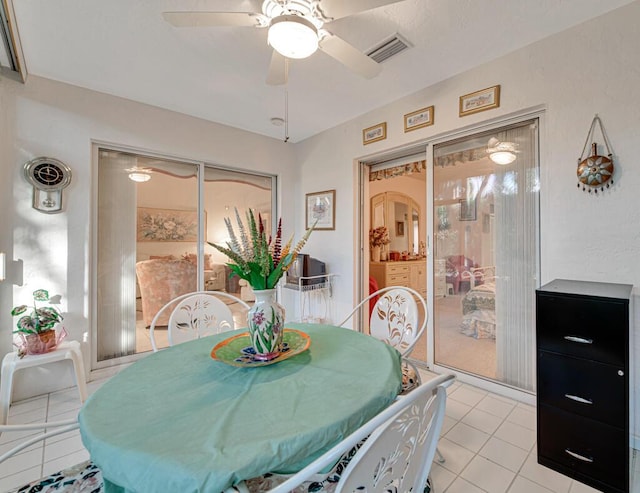 tiled dining area with ceiling fan