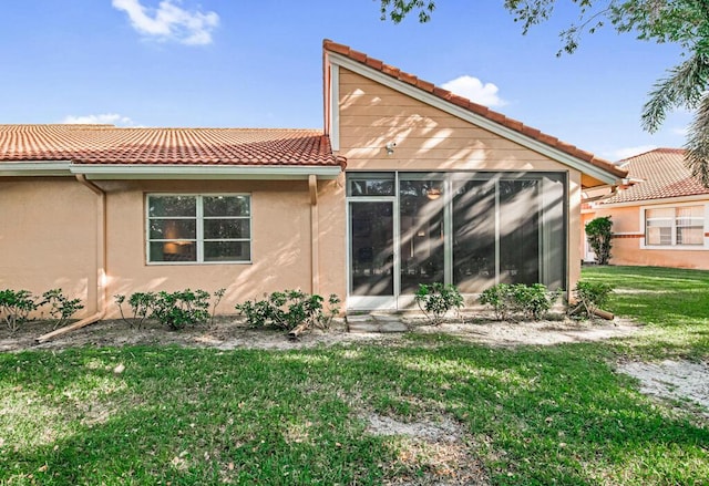 rear view of property featuring a lawn