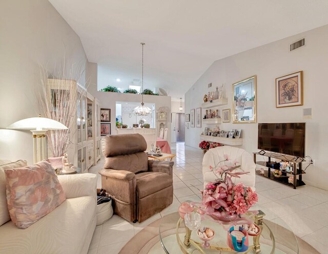 tiled living room featuring a notable chandelier and lofted ceiling